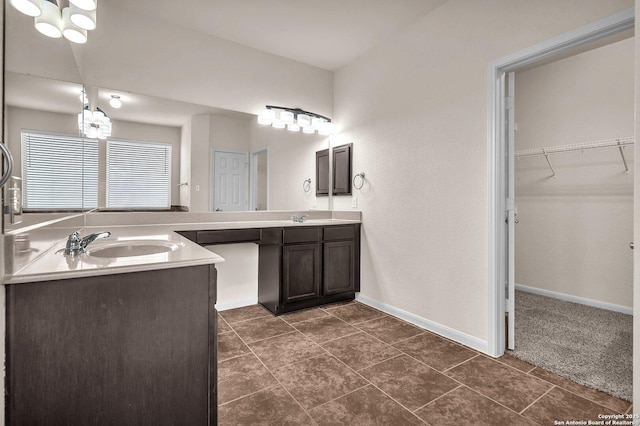 bathroom with tile patterned floors, vanity, and an inviting chandelier