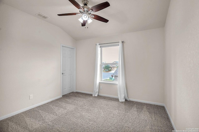 spare room featuring ceiling fan, carpet floors, and vaulted ceiling