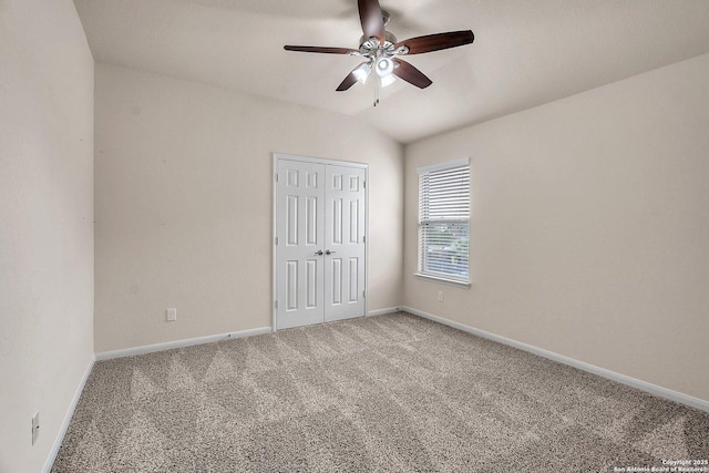 unfurnished bedroom with ceiling fan, lofted ceiling, carpet floors, and a closet