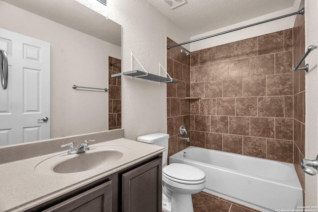 full bathroom with vanity, toilet, a textured ceiling, and tiled shower / bath combo