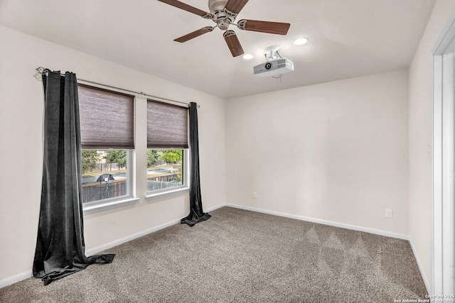 spare room with ceiling fan and carpet