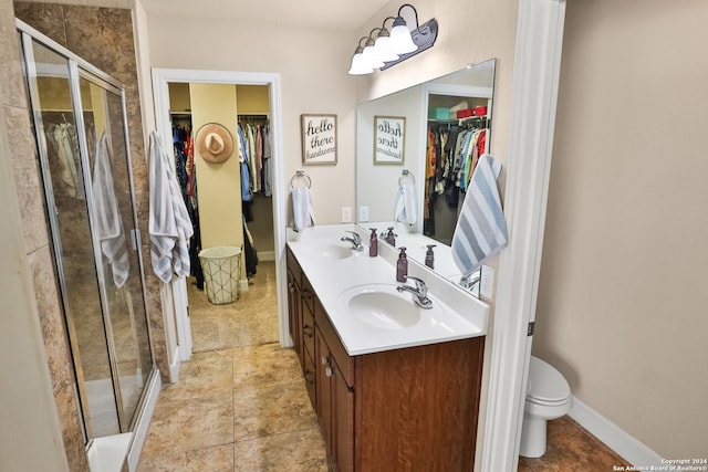 bathroom with vanity, toilet, and a shower with shower door