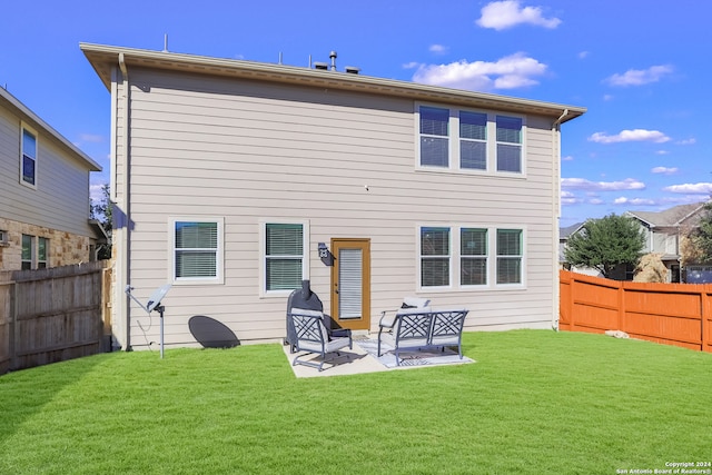 back of property with a yard and a patio area