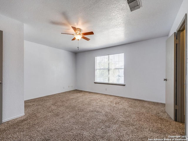 carpeted spare room featuring ceiling fan and a textured ceiling