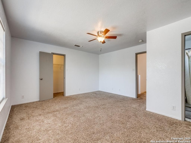 unfurnished room with ceiling fan, carpet floors, and a textured ceiling