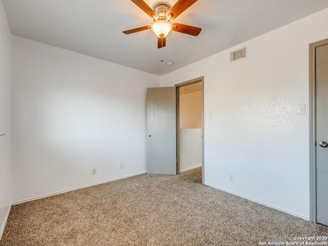 carpeted spare room featuring ceiling fan