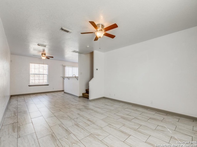 unfurnished room featuring ceiling fan and a textured ceiling