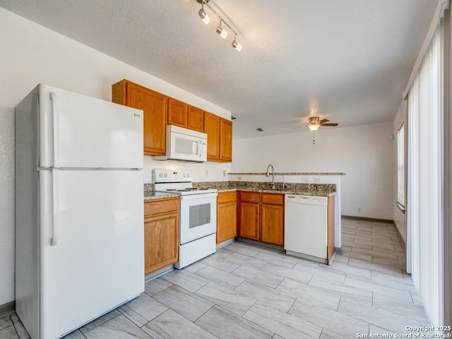 kitchen with kitchen peninsula, a textured ceiling, white appliances, ceiling fan, and sink