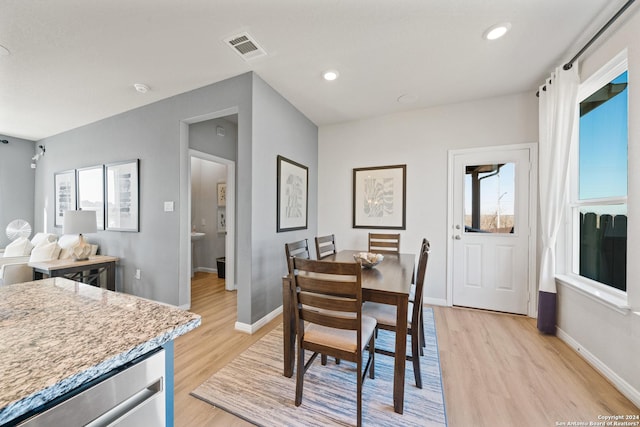 dining area with a wealth of natural light and light hardwood / wood-style flooring