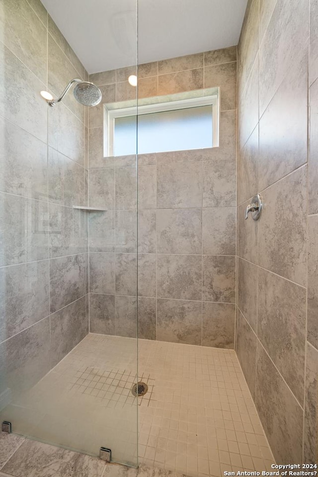 bathroom with a tile shower and plenty of natural light