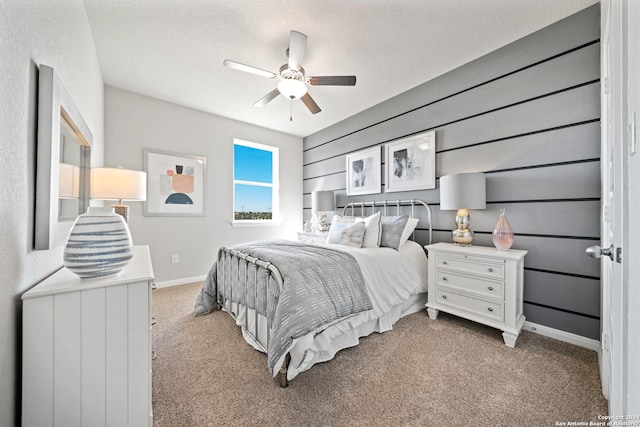 bedroom featuring light carpet, a textured ceiling, and ceiling fan