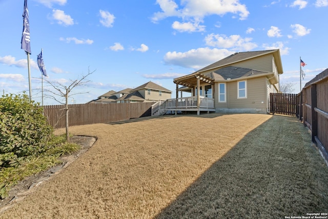 rear view of house with a deck and a yard