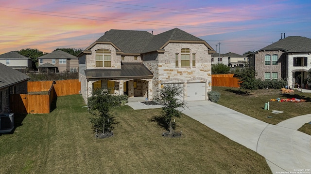 french provincial home with a lawn, central air condition unit, and a garage