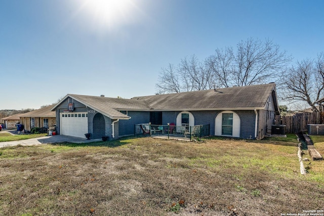 ranch-style home with a garage, central air condition unit, and a front yard