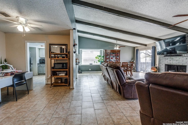 living room featuring lofted ceiling with beams, a textured ceiling, and a wealth of natural light