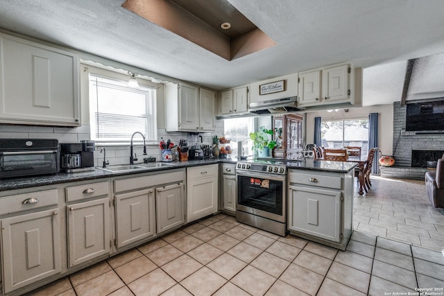 kitchen featuring white cabinetry, sink, kitchen peninsula, stainless steel electric range, and light tile patterned floors