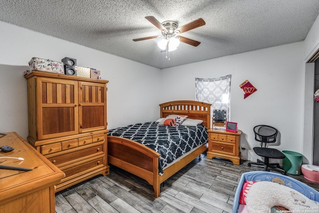 bedroom with hardwood / wood-style flooring, ceiling fan, and a textured ceiling