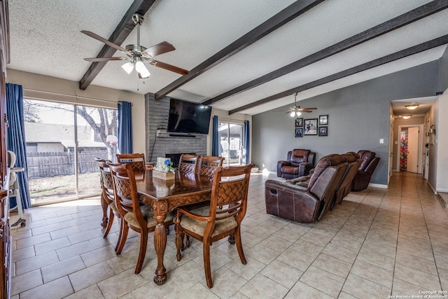 dining area with ceiling fan, light tile patterned flooring, lofted ceiling with beams, and a textured ceiling