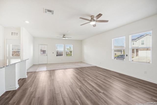 unfurnished living room featuring ceiling fan and hardwood / wood-style flooring