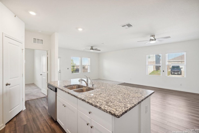 kitchen with white cabinetry, dishwasher, sink, light stone countertops, and an island with sink