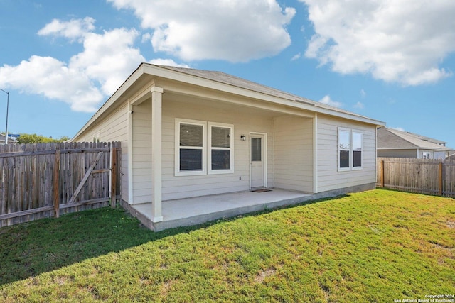 back of property featuring a lawn and a patio area