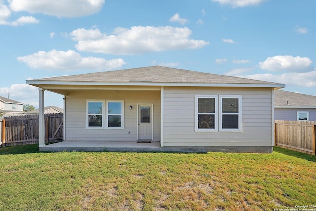 back of house featuring a patio area and a lawn