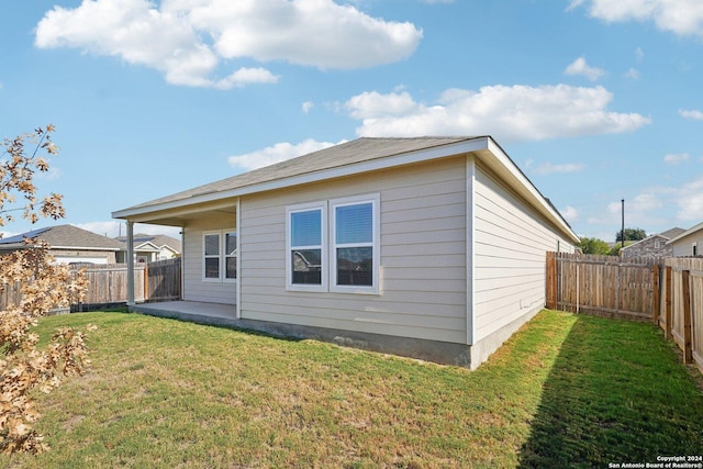 rear view of property featuring a patio and a lawn