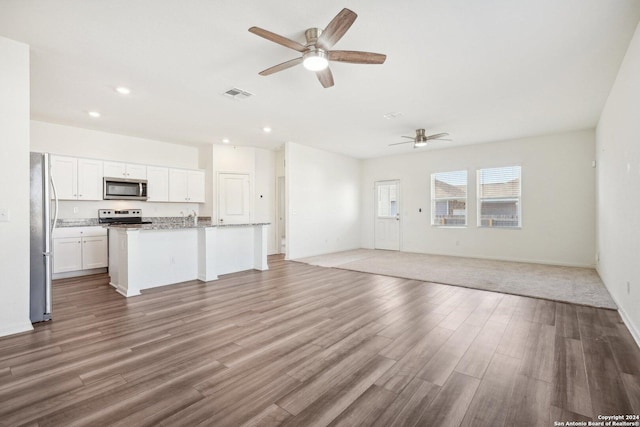 unfurnished living room featuring hardwood / wood-style floors, ceiling fan, and sink