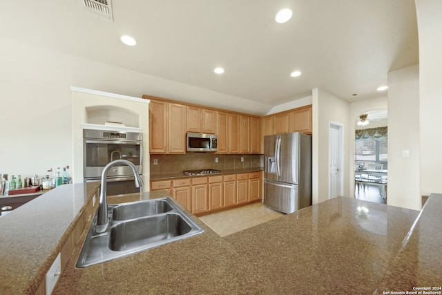 kitchen with tasteful backsplash, ceiling fan, sink, and appliances with stainless steel finishes