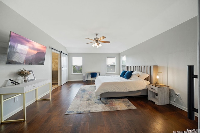 bedroom featuring a barn door, ceiling fan, and dark wood-type flooring