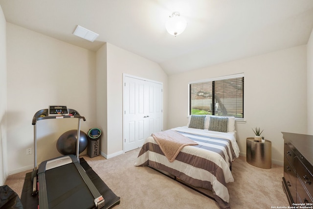 carpeted bedroom featuring vaulted ceiling and a closet