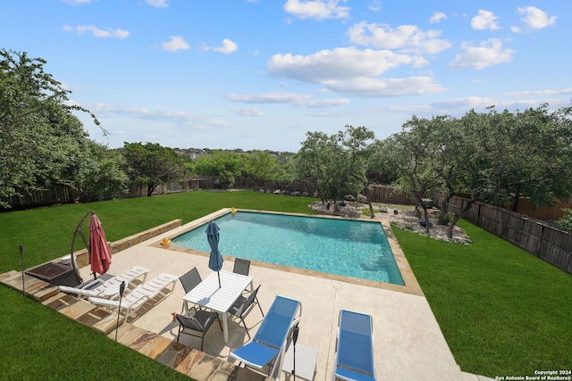 view of swimming pool with a lawn and a patio