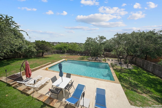 view of swimming pool featuring a patio area and a yard