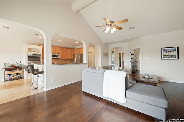 living room featuring beamed ceiling, ceiling fan, high vaulted ceiling, and hardwood / wood-style flooring