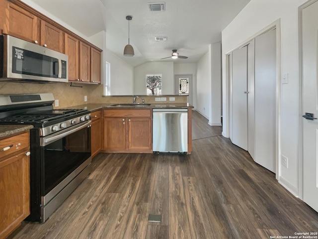 kitchen featuring sink, stainless steel appliances, tasteful backsplash, kitchen peninsula, and decorative light fixtures