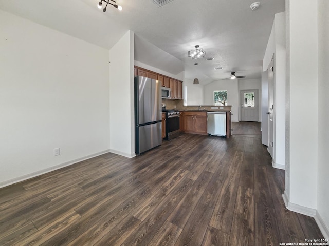 kitchen featuring ceiling fan, kitchen peninsula, pendant lighting, vaulted ceiling, and appliances with stainless steel finishes