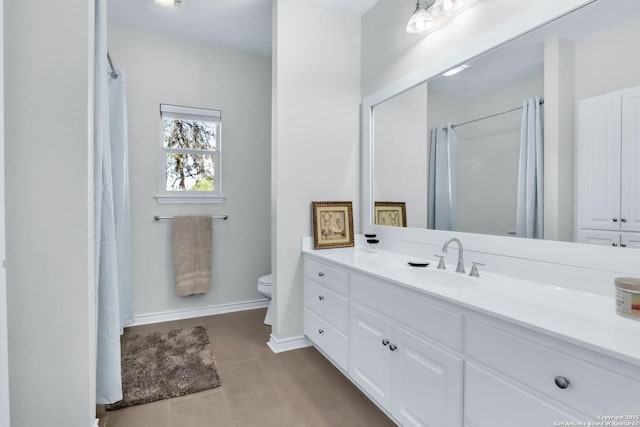 bathroom with tile patterned flooring, vanity, and toilet