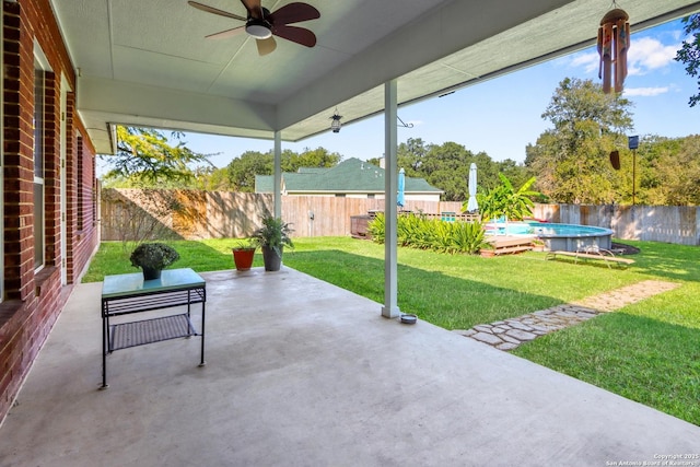 view of patio with ceiling fan and a fenced in pool