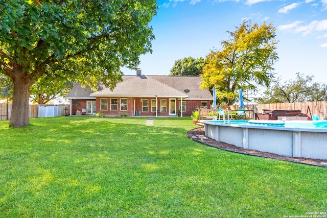 view of yard with a swimming pool with hot tub