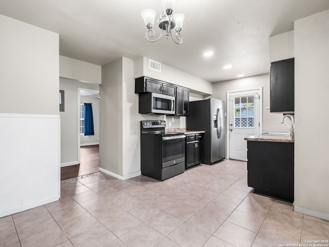 kitchen with sink, appliances with stainless steel finishes, ceiling fan with notable chandelier, and light tile patterned flooring