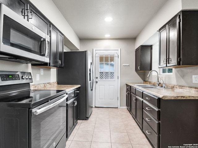 kitchen with appliances with stainless steel finishes, light tile patterned floors, and sink