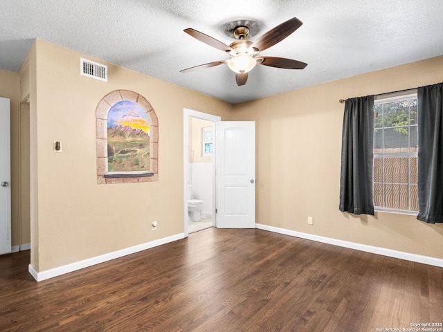 empty room with dark hardwood / wood-style floors, ceiling fan, and a textured ceiling