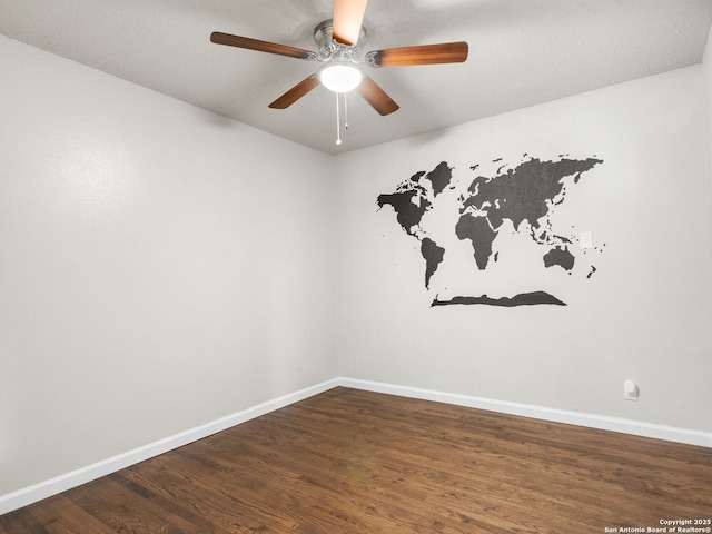 spare room with dark hardwood / wood-style floors and ceiling fan