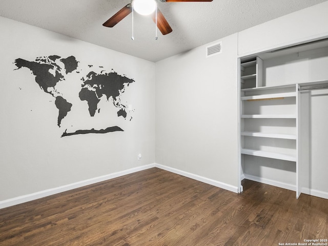 unfurnished bedroom featuring a textured ceiling, ceiling fan, and dark wood-type flooring