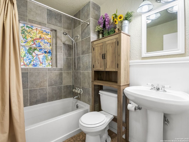 full bathroom with a textured ceiling, sink, toilet, and shower / tub combo with curtain