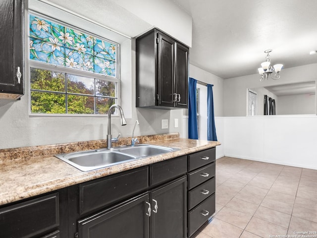 kitchen featuring pendant lighting, light tile patterned floors, sink, and a chandelier