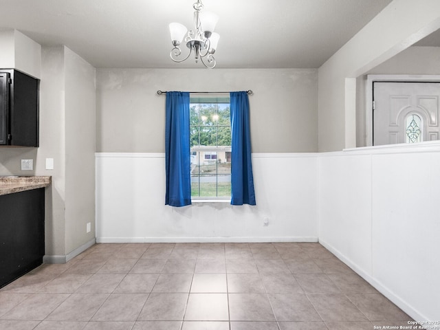 unfurnished dining area featuring a chandelier and light tile patterned flooring