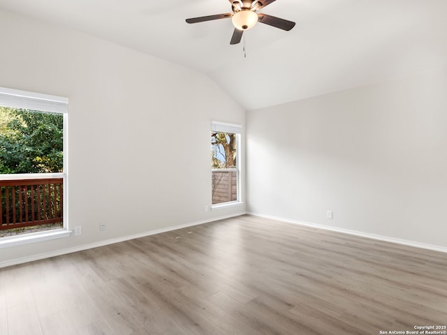 unfurnished room with hardwood / wood-style flooring, ceiling fan, a healthy amount of sunlight, and vaulted ceiling