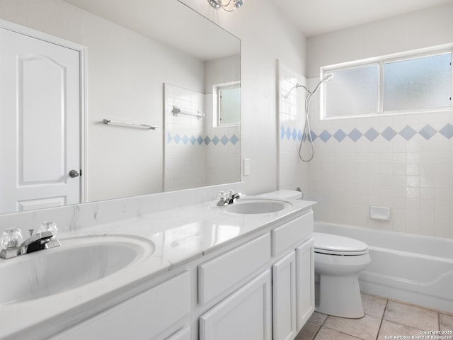 full bathroom with tiled shower / bath, tile patterned flooring, vanity, and toilet