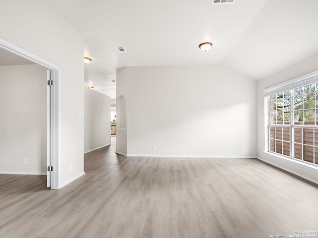 unfurnished room with light hardwood / wood-style floors and vaulted ceiling